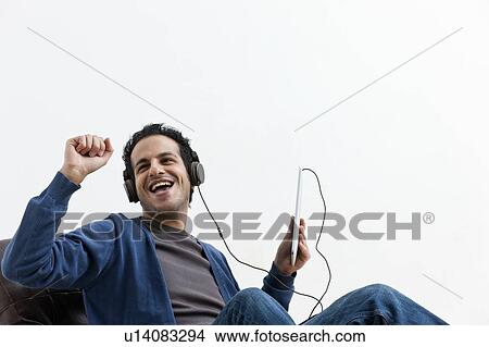 Man in headphones dancing in chair View Large Photo Image Picture - Man in headphones dancing in chair. Fotosearch