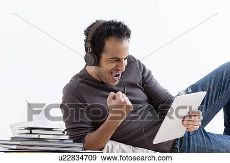 Man listening to tablet computer View Large Photo Image Stock Photo - Man listening to tablet computer. Fotosearch