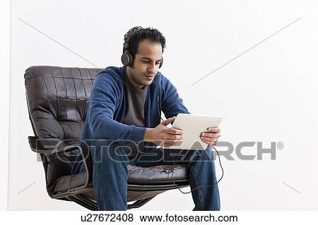 Man listening to tablet computer View Large Photo Image Stock Photo - Man listening to tablet computer. Fotosearch