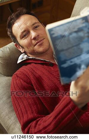 Man reading book on sofa View Large Photo Image Stock Image - Man reading book on sofa. Fotosearch