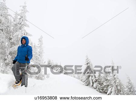 Man snowshoeing on snowy hillside View Large Photo Image Stock Photo - Man snowshoeing on snowy hillside. Fotosearch