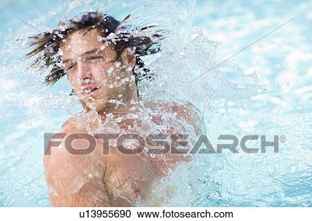 Stock Image - Man splashing in pool. Fotosearch