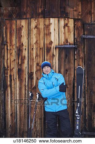 Stock Image - Man standing with skis and poles. Fotosearch