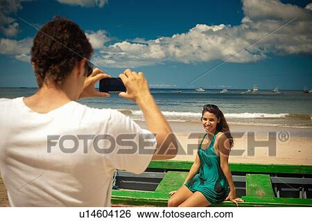 Stock Photograph - Man taking picture of girlfriend. Fotosearch
