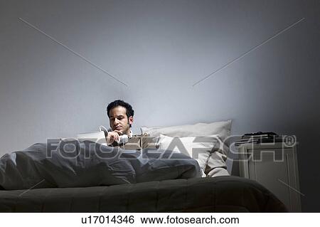 Stock Photograph - Man using tablet computer in bed. Fotosearch