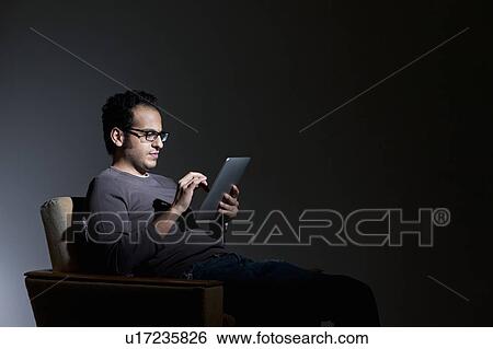 Stock Photograph - Man using tablet computer. Fotosearch