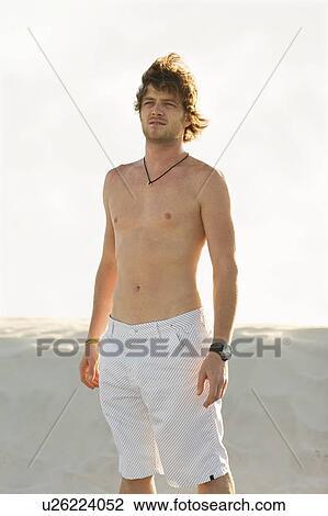 Man wearing shorts on beach View Large Photo Image Stock Image - Man wearing shorts on beach. Fotosearch