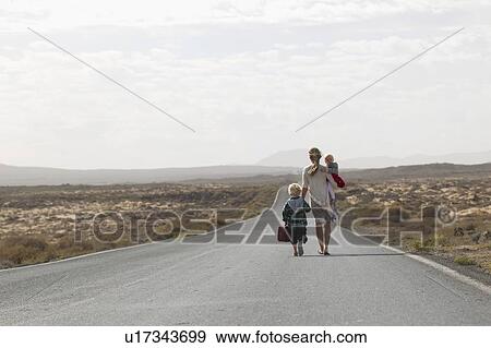 Stock Photo - Mother and children on rural road. Fotosearch