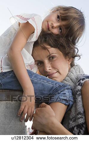 Picture - Mother and daughter hugging outdoors. Fotosearch