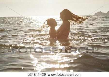 Mother and daughter playing in ocean View Large Photo Image Stock Photo - Mother and daughter playing in ocean. Fotosearch