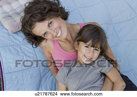 Picture - Mother and daughter relaxing on blanket. Fotosearch
