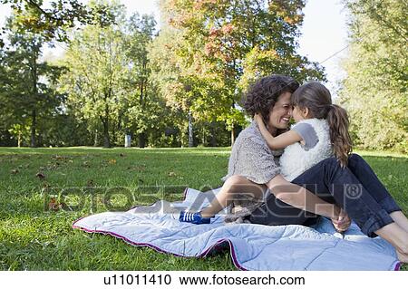 Stock Image - Mother and daughter relaxing on blanket. Fotosearch