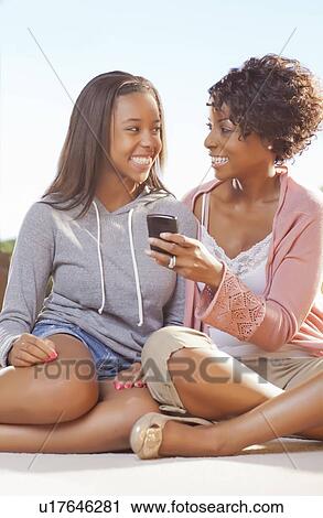Mother and daughter using cell phone View Large Photo Image Stock Image - Mother and daughter using cell phone. Fotosearch