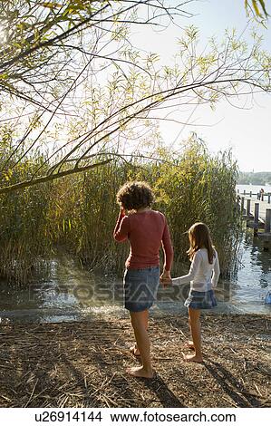 Mother and daughter walking by lake View Large Photo Image Picture - Mother and daughter walking by lake. Fotosearch