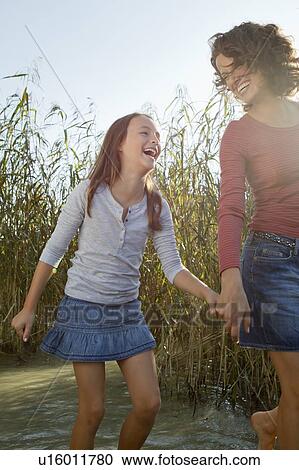 Mother and daughter walking in pond View Large Photo Image Stock Image - Mother and daughter walking in pond. Fotosearch