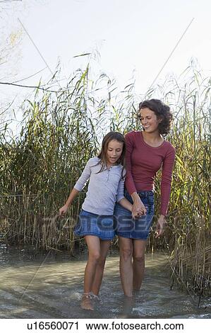 Mother and daughter walking in pond View Large Photo Image Stock Image - Mother and daughter walking in pond. Fotosearch