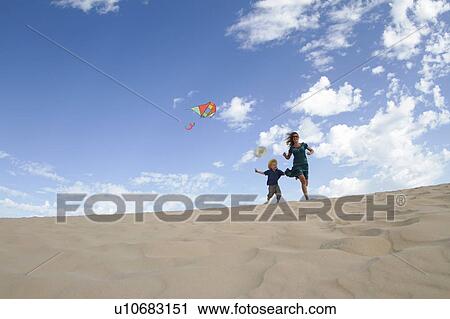 Mother and son flying kite on beach View Large Photo Image Stock Image - Mother and son flying kite on beach. Fotosearch
