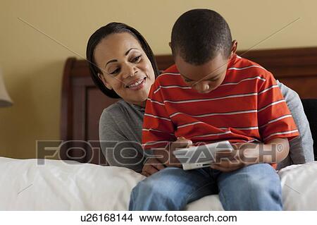 Mother and son playing video games View Large Photo Image Picture - Mother and son playing video games. Fotosearch