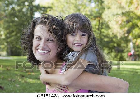 Stock Photo - Mother carrying daughter outdoors. Fotosearch
