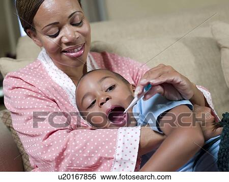 Stock Photograph - Mother taking sons temperature. Fotosearch
