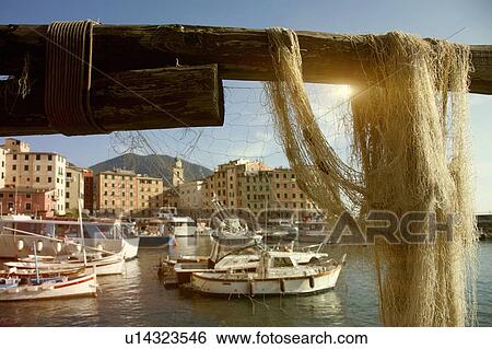 Stock Photograph - Netting hanging on rail at pier. Fotosearch