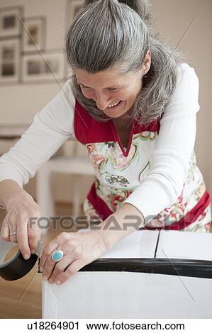 Older woman wrapping cardboard box View Large Photo Image Stock Image - Older woman wrapping cardboard box. Fotosearch