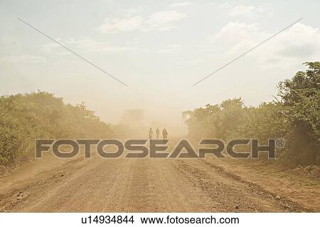 Picture - People riding bicycles on dirt path. Fotosearch