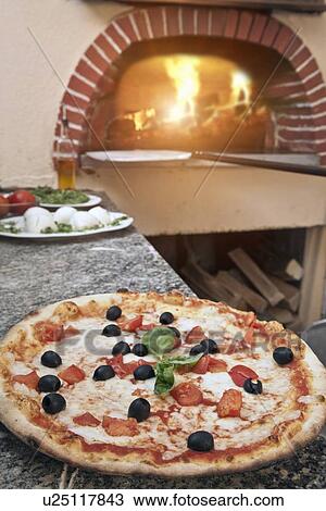 Stock Image - Pizza on counter in kitchen. Fotosearch