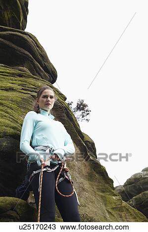 Rock climber tying ropes by boulder View Large Photo Image Stock Image - Rock climber tying ropes by boulder. Fotosearch