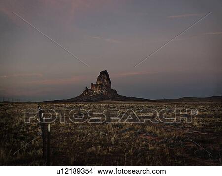 Picture - Rock formation in grassy desert. Fotosearch