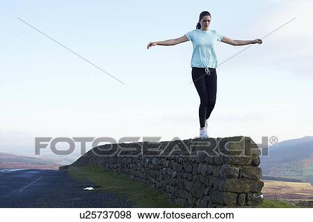 Runner balancing on rock wall View Large Photo Image Stock Photo - Runner balancing on rock wall. Fotosearch