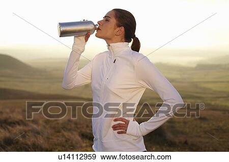 Runner drinking water in rural landscape View Large Photo Image Stock Photo - Runner drinking water in rural landscape. Fotosearch