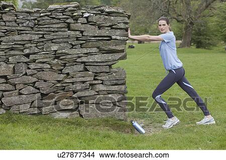 Runner stretching against rock wall View Large Photo Image Picture - Runner stretching against rock wall. Fotosearch