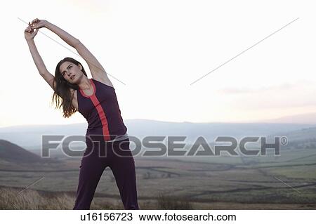 Stock Image - Runner stretching in rural landscape. Fotosearch