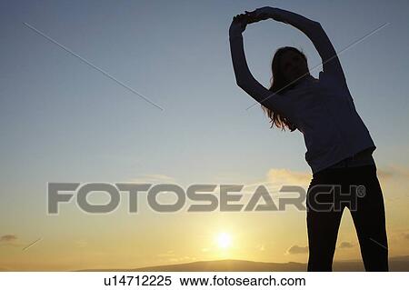 Stock Photography - Runner stretching in rural landscape. Fotosearch
