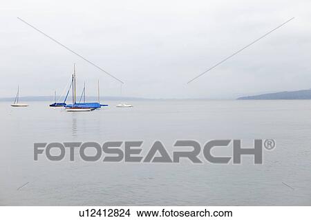 Sailboats on still ocean View Large Photo Image Picture - Sailboats on still ocean. Fotosearch