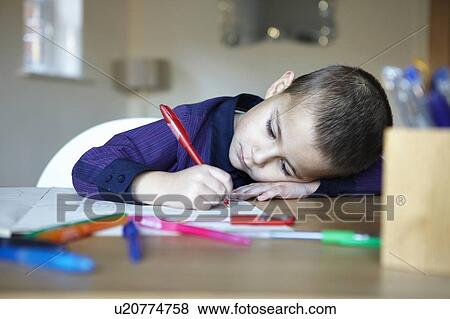 Schoolboy writing at desk View Large Photo Image Stock Photo - Schoolboy writing at desk. Fotosearch