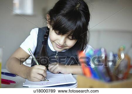 Schoolgirl writing at desk View Large Photo Image Stock Photo - Schoolgirl writing at desk. Fotosearch