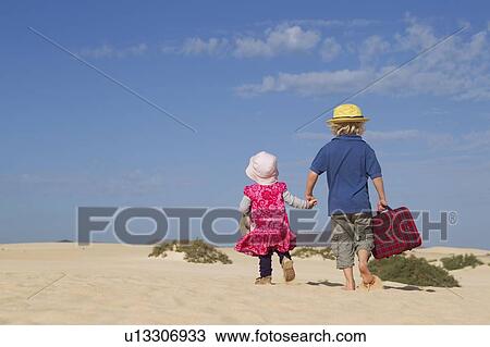 Siblings walking together on beach View Large Photo Image Stock Image - Siblings walking together on beach. Fotosearch
