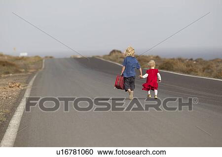Siblings walking together on rural road View Large Photo Image Stock Image - Siblings walking together on rural road. Fotosearch