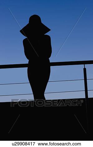 Stock Photo - Silhouette of woman in sunhat outdoors. Fotosearch
