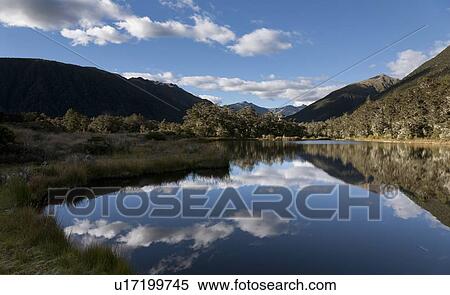 Stock Photography - Sky reflected in lake in urban landscape. Fotosearch