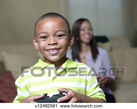 Smiling boy holding game controller View Large Photo Image Stock Image - Smiling boy holding game controller. Fotosearch