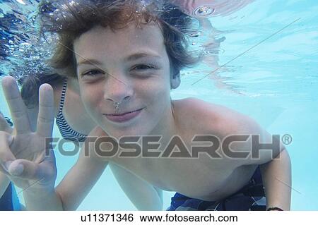 Smiling boy playing in pool View Large Photo Image Stock Photograph - Smiling boy playing in pool. Fotosearch