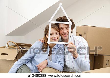 Smiling couple holding house symbol View Large Photo Image Stock Photo - Smiling couple holding house symbol. Fotosearch