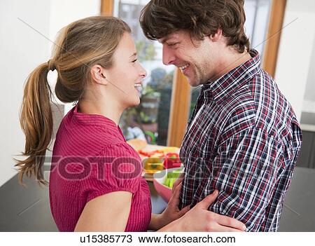 Smiling couple hugging in kitchen View Large Photo Image Stock Image - Smiling couple hugging in kitchen. Fotosearch