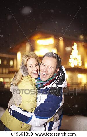Smiling couple hugging in snow View Large Photo Image Stock Photo - Smiling couple hugging in snow. Fotosearch