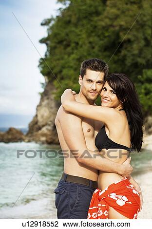 Smiling couple hugging on beach View Large Photo Image Stock Image - Smiling couple hugging on beach. Fotosearch