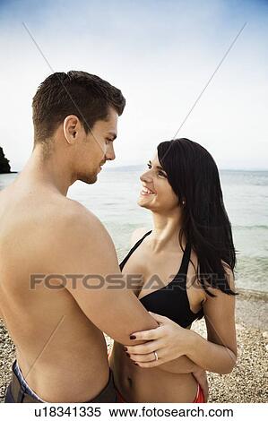 Smiling couple hugging on beach View Large Photo Image Stock Photography - Smiling couple hugging on beach. Fotosearch