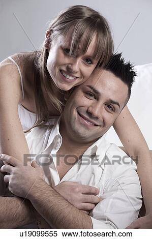 Smiling couple hugging on couch View Large Photo Image Stock Photography - Smiling couple hugging on couch. Fotosearch